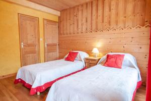 two beds in a room with wooden walls at PLACE EGLISE 2 in Morzine
