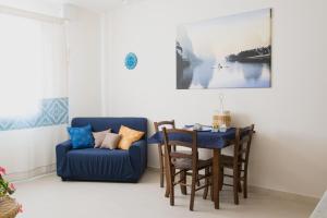- un salon avec une table et une chaise bleue dans l'établissement S'eredeu Apartments, à Sestu
