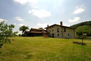 stary kamienny dom na polu trawy w obiekcie Casa Rural Garabilla w mieście Santa Coloma