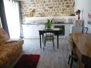 uma cozinha e sala de jantar com uma mesa e um sofá em L'Ancienne Ecole em Silhac