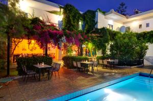 a courtyard with tables and chairs and a swimming pool at Spacious Apartment in Plakias in Plakias