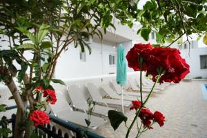 a group of white chairs and red flowers at Spacious Apartment in Plakias in Plakias