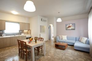 a living room with a table and a blue couch at Spacious Apartment in Plakias in Plakias