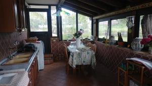 eine Küche mit einem Tisch und einer Theke sowie einige Fenster in der Unterkunft Mongbeach in Acireale