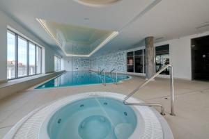 een zwembad met een bad in het midden van een gebouw bij Live & Travel Apartments - Waterlane Island in Gdańsk