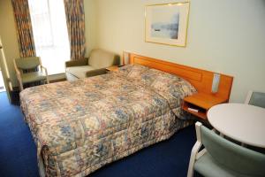 a hotel room with a bed and a table and chair at Mildura Plaza Motor Inn in Mildura