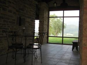 Pokój ze stołem, krzesłami i oknem w obiekcie Casa Rural Garabilla w mieście Santa Coloma