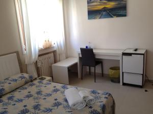 a hotel room with a bed and a desk and a table at La Castellese in Aci Castello