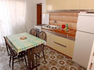 cocina con mesa, fregadero y nevera en Apartments Katnić, en Hvar
