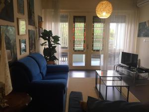 ein Wohnzimmer mit einem blauen Sofa und einem Tisch in der Unterkunft Bruseschi in Grado