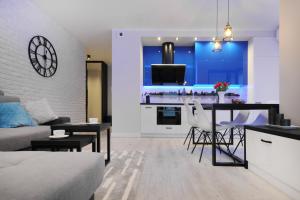 a living room with a couch and a table with chairs at Bulwary Wislane P&O Serviced Apartments with AC in Warsaw