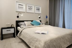 a bedroom with a bed with two books on it at Bulwary Wislane P&O Serviced Apartments with AC in Warsaw