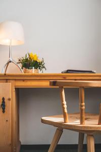 a wooden desk with a lamp and a laptop on it at Hotel Post Sils Maria in Sils Maria