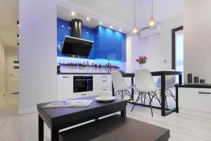a kitchen and living room with a table and chairs at Bulwary Wislane P&O Serviced Apartments with AC in Warsaw