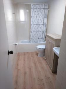 uma casa de banho com uma banheira, um WC e um lavatório. em Manolo piso em Portomarín