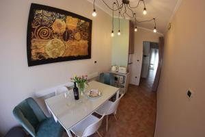 a dining room with a white table and chairs at Room and Apartment Doris in Umag