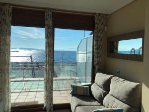 a living room with a couch and a large window at Apartamento frente al mar in San Pedro