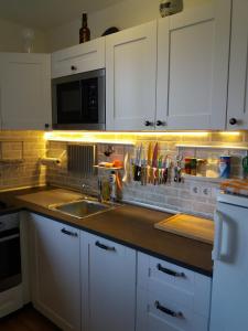 eine Küche mit weißen Schränken, einer Spüle und einer Theke in der Unterkunft Apartma mit Seeblick in Sankt Gilgen