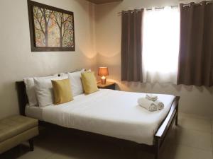 a bedroom with a large white bed with a window at Residenciale Boutique Apartments in Manila