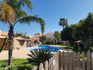 a swimming pool in a yard with a wooden fence at Akutuna - Casa Familiar con Piscina , Garaje & Pista de Padel in Zahara de los Atunes