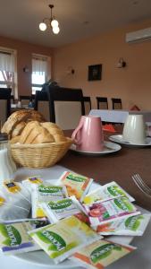 uma mesa com um prato de pão e um cesto de comida em Miklós Fogadó és Étterem em Mátraterenye