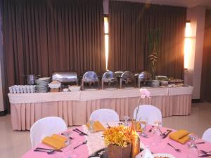 a table with white chairs and a pink table cloth at Residenciale Boutique Apartments in Manila