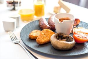 a plate of food with donuts and a cup of coffee at Edgbaston Park Hotel Birmingham in Birmingham