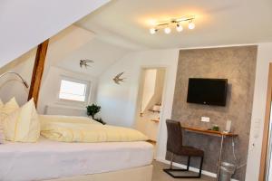 a bedroom with a bed and a desk and a television at Pension Alscher Garni in Goslar
