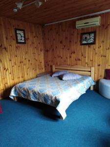 1 dormitorio con 1 cama en una pared de madera en Hostel Hola en Chernihiv