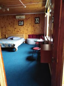 Hostel Hola في تشيرنيهيفسكا: غرفة بسرير وطاولة وكراسي