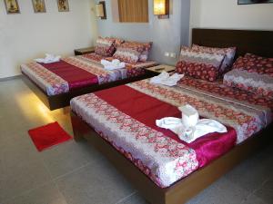 Habitación con 3 camas con sábanas rojas y blancas. en Bellevue Resort, en Puerto Galera