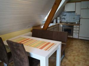een kleine keuken met een witte tafel en stoelen bij Klausseppenhof in Oberwolfach