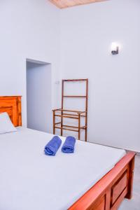 a bedroom with a bed with two blue towels on it at Saman Beach Guest House in Galle