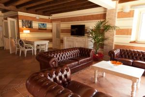a living room with brown leather couches and a table at Agriturismo Creta Rossa in Torre di Ruggiero