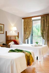 ein Hotelzimmer mit 2 Betten und einem Fenster in der Unterkunft Monasterio De Piedra in Nuévalos