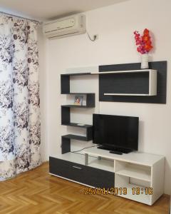uma sala de estar com uma televisão na parede em Apartment Sunrise em Sveti Stefan