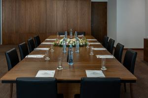 a conference room with a long wooden table with chairs at Pavlo Napa Beach Hotel in Ayia Napa