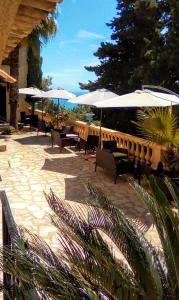um pátio com guarda-sóis, mesas e cadeiras em Villa Azur Cap d'Ail em Cap d'Ail