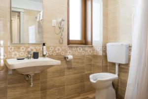 La salle de bains est pourvue d'un lavabo, de toilettes et d'un miroir. dans l'établissement Villa Marra, à Trieste