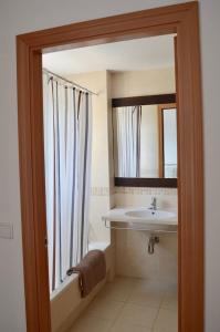 ein Bad mit einem Waschbecken und einem Spiegel in der Unterkunft Chalet adosado en Costa Miño a un paso de la playa in Miño