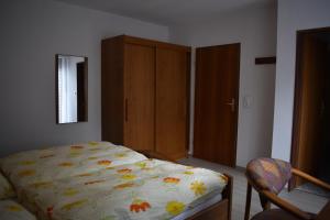 1 dormitorio con 1 cama y armario de madera en Pension Haus am Waldesrand, en Schieder-Schwalenberg