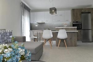 a kitchen and living room with a couch and chairs at Crystallia SeaSide Maisonette by RentalsPro- Nea Moudania in Nea Moudania