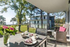 un patio con una mesa con un jarrón de flores en Appartement Haffperle-Oase am Haff, en Garz