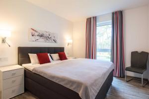 a bedroom with a bed and a chair and a window at Appartement Haffperle-Oase am Haff in Garz-Usedom