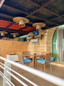 a patio with a table and chairs on a porch at Le Blanc Bleu in Jbeil