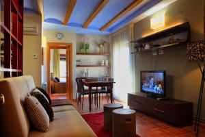a living room with a couch and a tv and a table at Apartamentos Casa Molinero in Buera