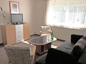 a living room with a tv and a coffee table at Apartment near the forest in Gößweinstein