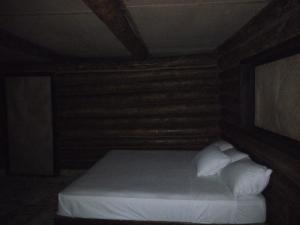 een slaapkamer met een bed met witte lakens en kussens bij Sierraverde Cabins Cabaa la Palma in Tamasopo