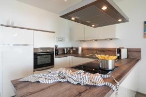 a kitchen with a counter with a pot of utensils at Appartement Haffperle-Oase am Haff in Garz