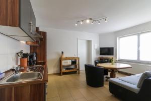 eine Küche und ein Wohnzimmer mit einem Waschbecken und einem Tisch in der Unterkunft Ferienwohnung Kressmann in Neppermin